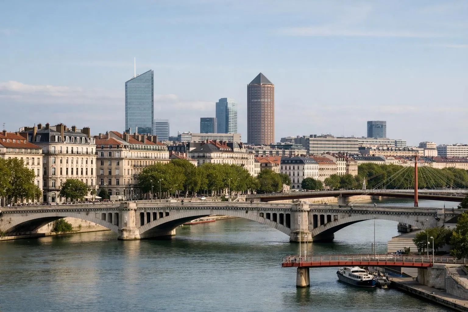 Vue aérienne réaliste de Lyon avec le Rhône, immeubles résidentiels haussmanniens et modernes, quartiers d'affaires en arrière-plan, lumière naturelle de fin d'après-midi, perspective urbaine dynamique montrant la densité et l'attractivité de la ville, toits en tuiles rouges typiques, ponts élégants, ambiance d'investissement immobilier stratégique, photo éditoriale professionnelle sans texte