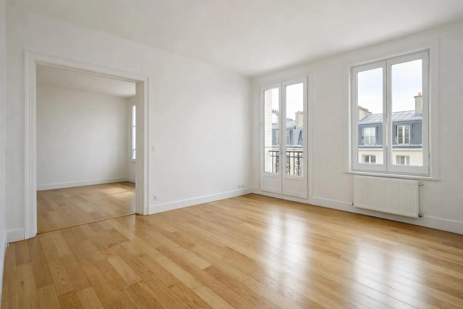 Interior of an empty unfurnished French apartment with bare white walls, wooden parquet flooring, large windows letting in natural daylight, visible radiator, representing a location vide ready for rental contract signing, realistic photography style with neutral beige and grey tones, no furniture, clean and bright atmosphere suitable for residential rental market in France, no text or logos visible